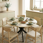 Natural wood round dining table with black base for shared meals
