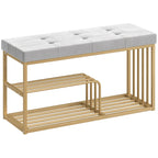 Grey tufted shoe storage bench with upholstered seat and gold-toned steel two-tier rack
