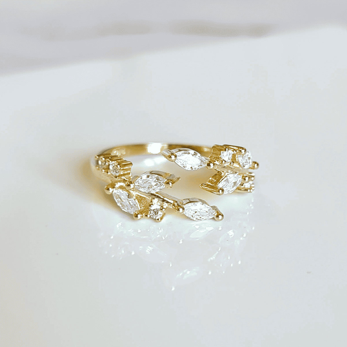 Gold-tone adjustable ring with marquise-cut clear stones, prong-set band