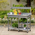 Grey outdoor potting table with drawer, metal tabletop, and two-tier storage shelves