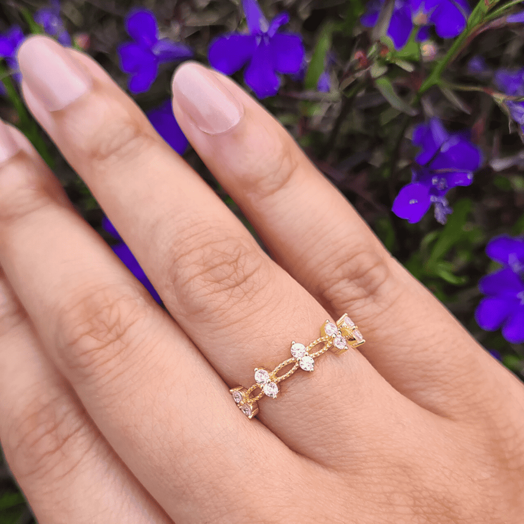 Gold crystal ring with stacked marquise stones and small round accents on finger
