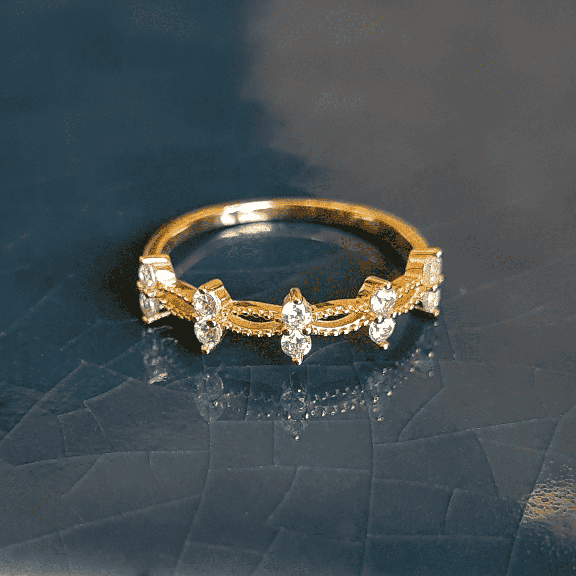 Gold crystal ring with five stones and slim openwork band, glossy prong settings