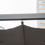 Retractable roof canopy edge with hanging grommet on dark grey aluminum gazebo