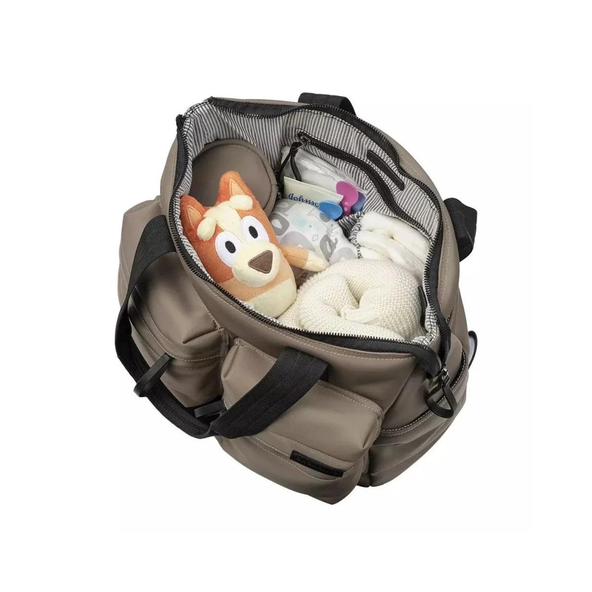 Mink changing bag open with striped interior and multiple pockets, including plush toy