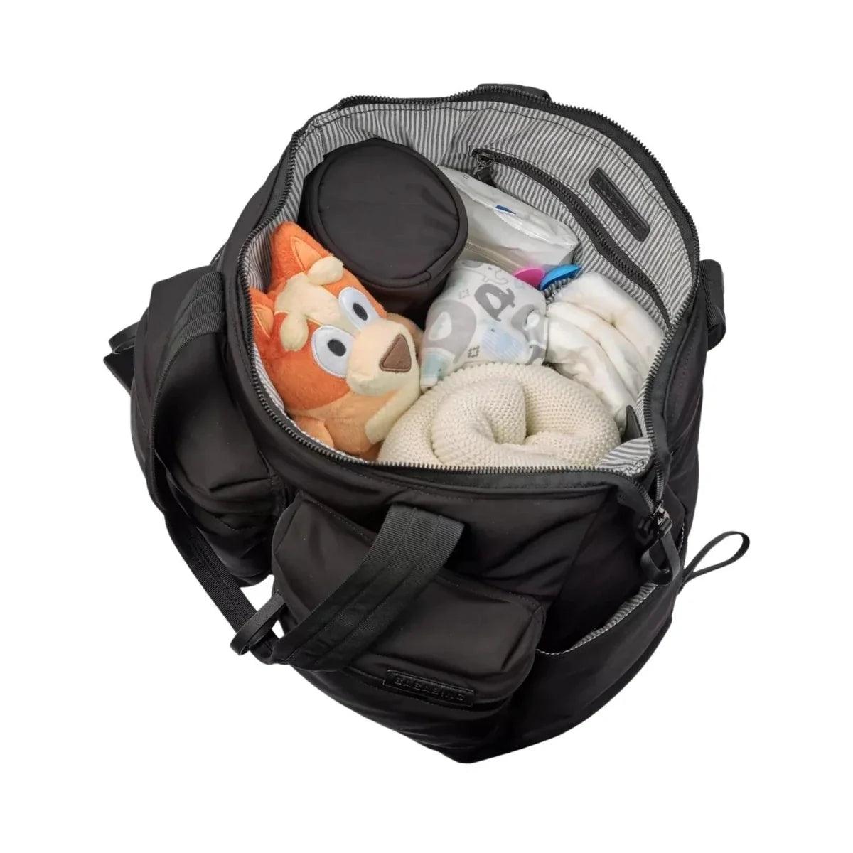 Black changing bag open interior with compartments and small baby items