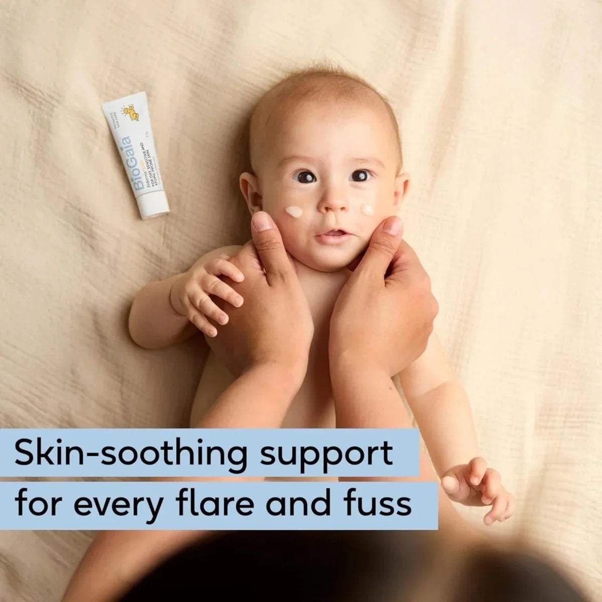 Baby receiving skin-soothing ointment, small white tube in view