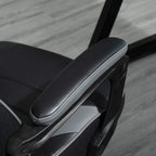 Grey padded armrest and side control panel on a racing gaming chair