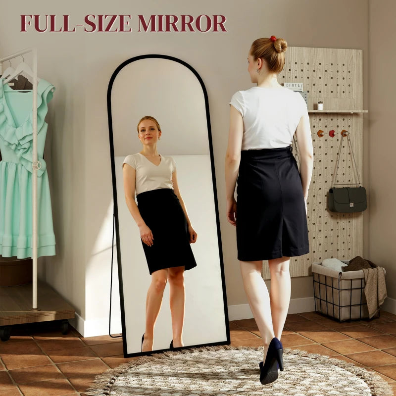 Black arched standing mirror showing full-body reflection in a thin frame
