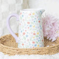 White ceramic flower jug with lilac handle and spring floral print
