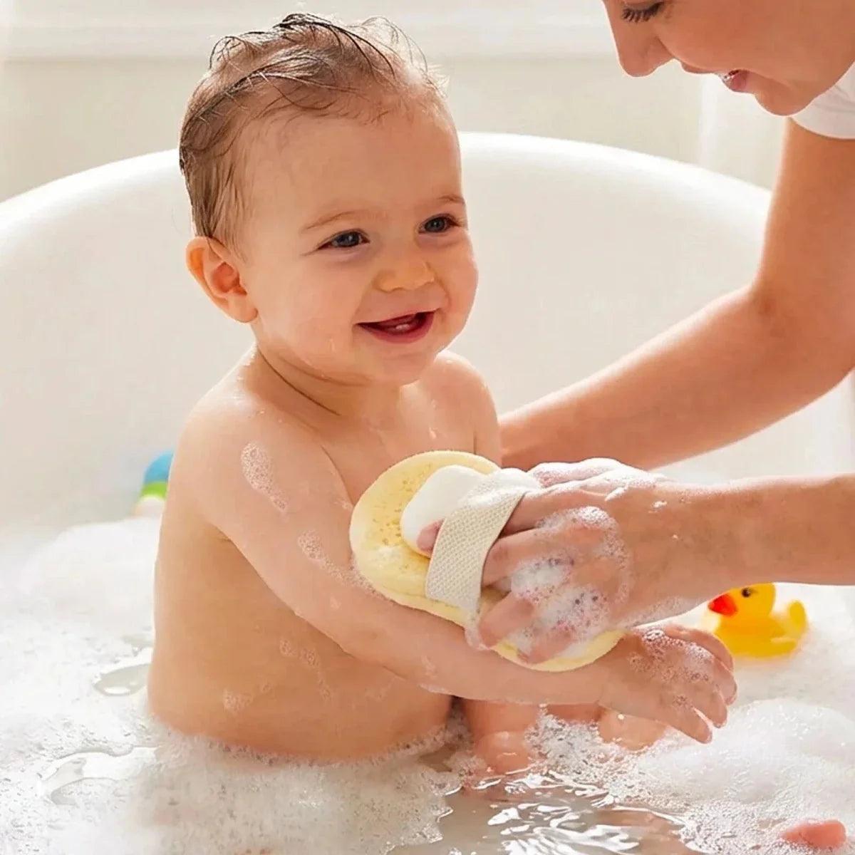 Baby being bathed with a sponge and soap bar in hand