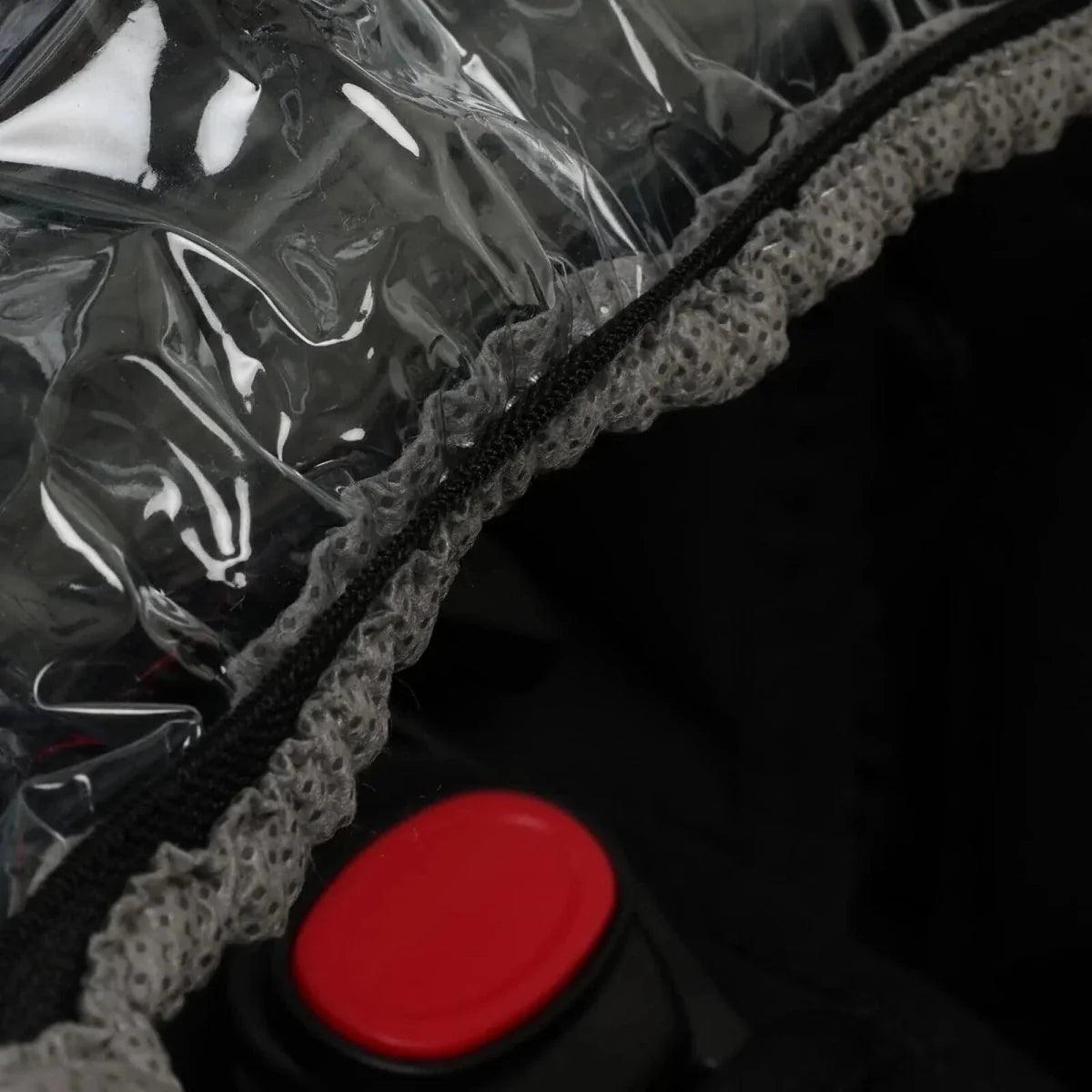 Rain cover seam detail with red snap button and textured gray mesh trim