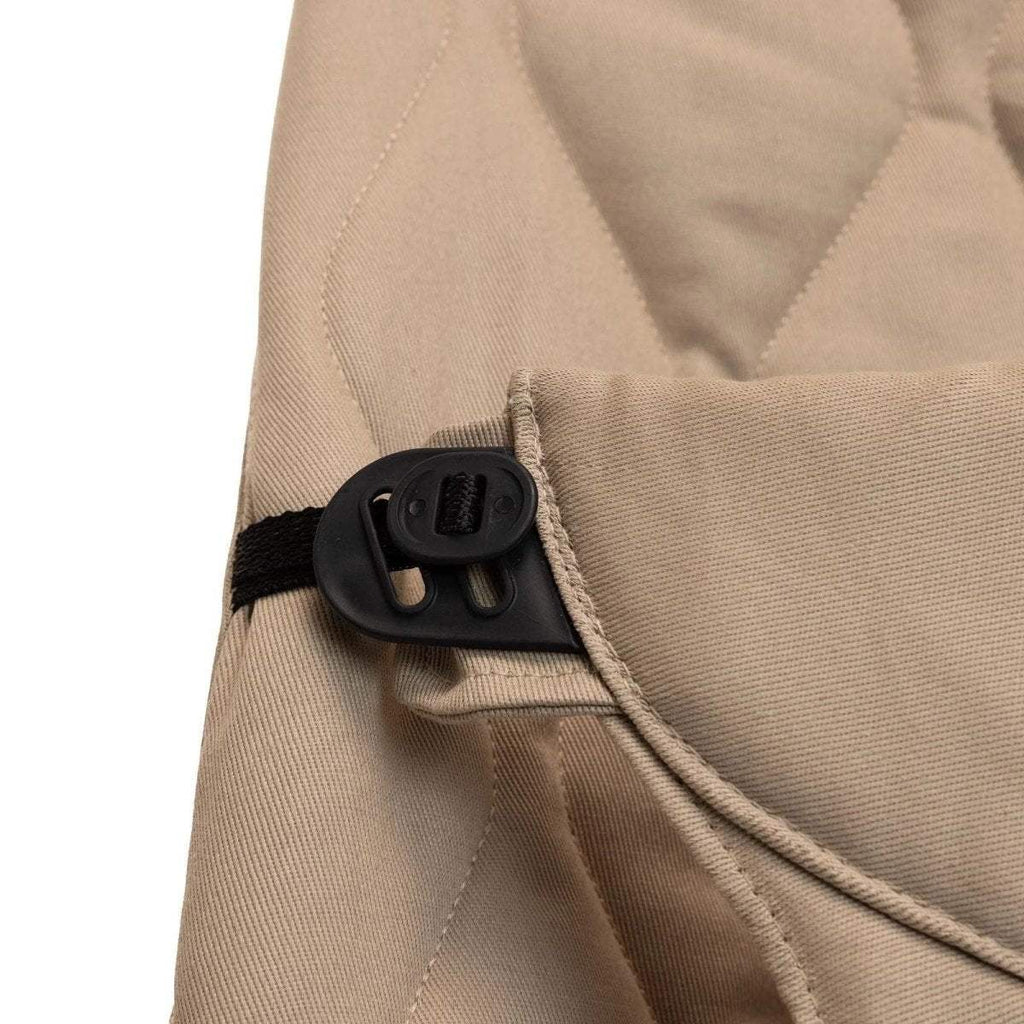 Beige bouncer harness with black buckle and strap adjuster detail