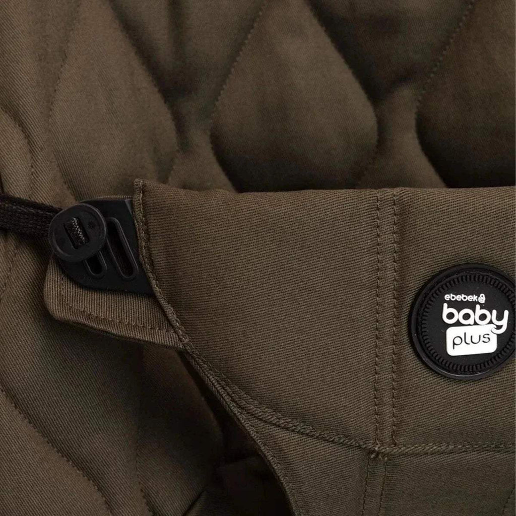 Khaki baby bouncer with side strap and round “baby plus” logo patch.