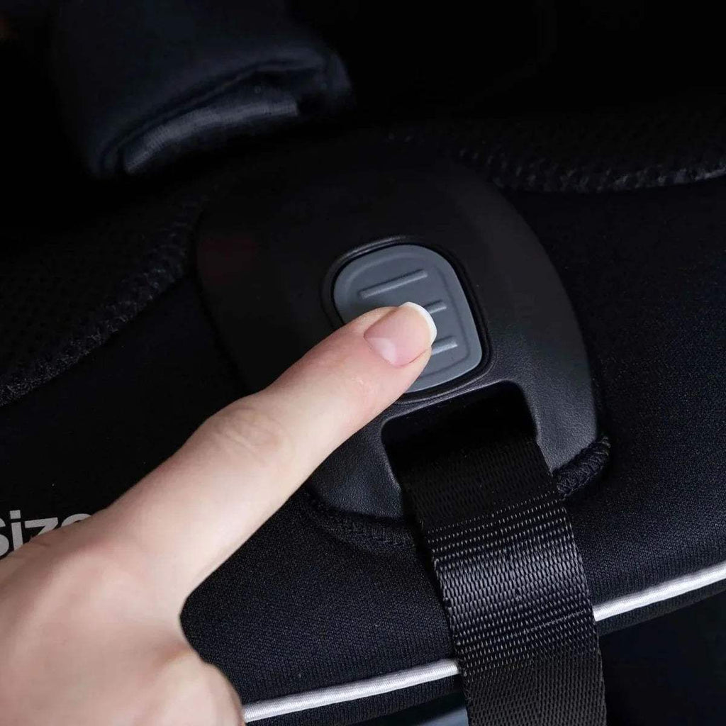 Black car seat chest strap with grey release button and adjustable webbing