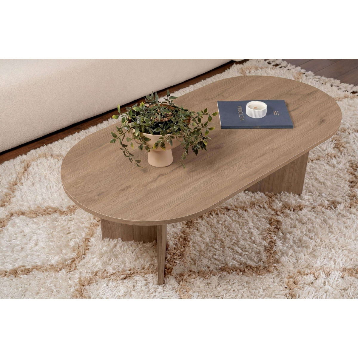 Oak oval coffee table with curved edge tabletop and central support leg.