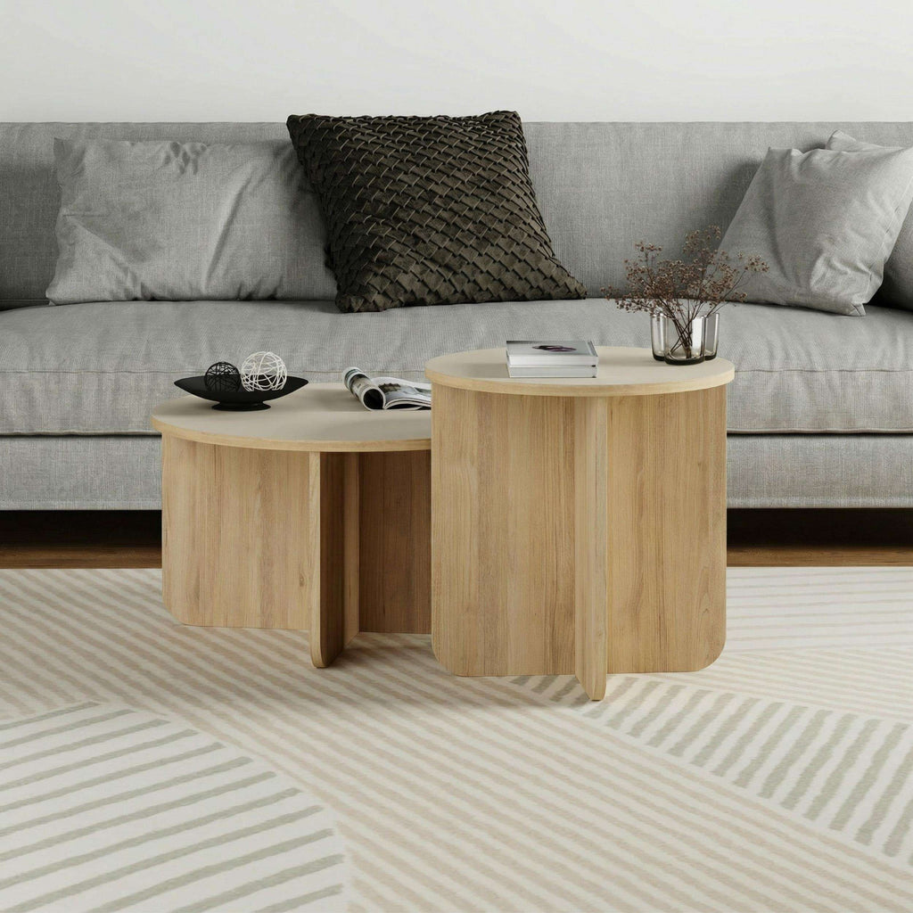 Light oak round nesting coffee table set with tabletop decor and folded legs