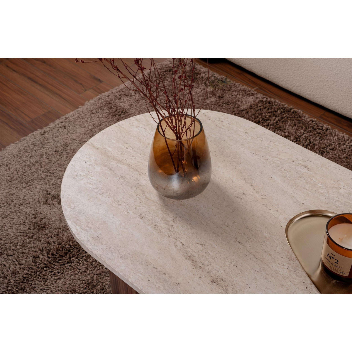 Oval coffee table with light stone surface and dark wood base