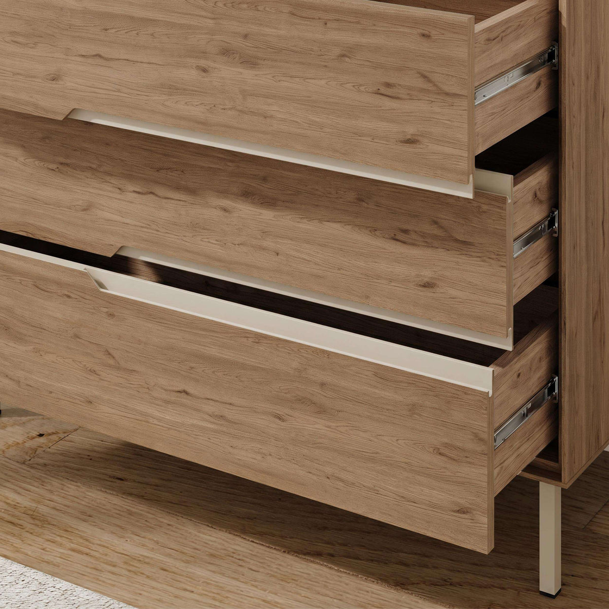 Chest of drawers with open drawers and light wood finish, showing long white handle
