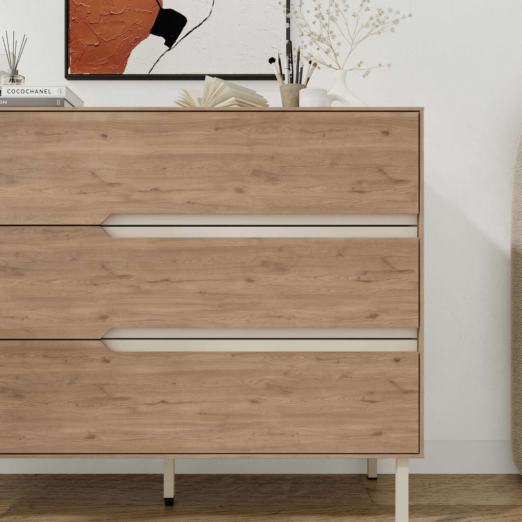 Front view chest of drawers with three light-wood drawers and long white bar handles