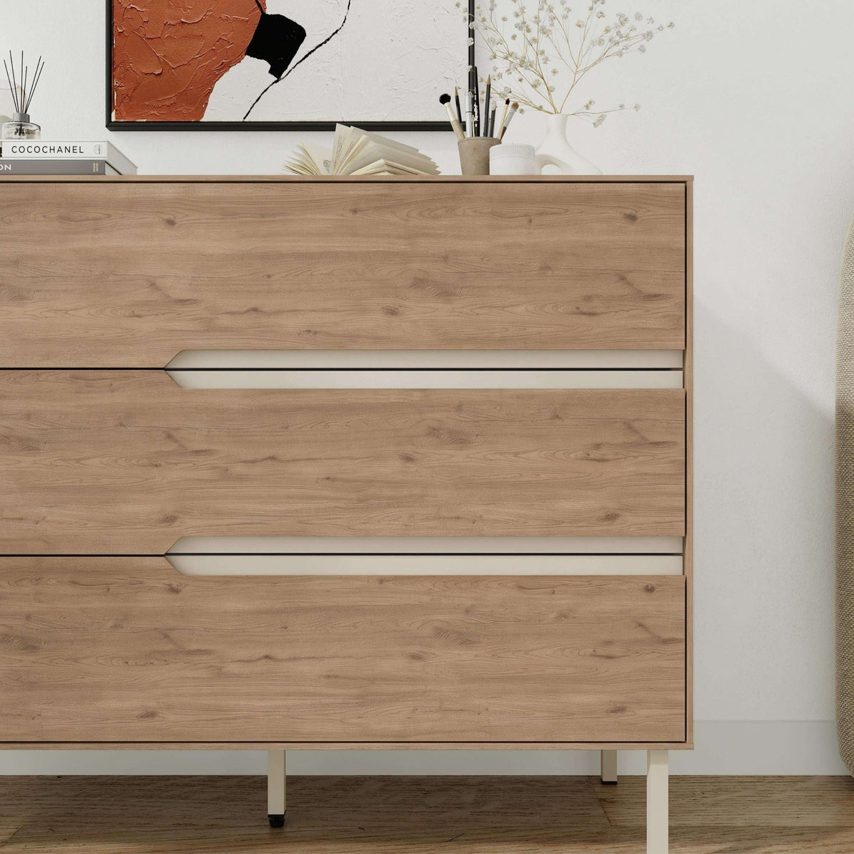 Front view chest of drawers with three light-wood drawers and long white bar handles
