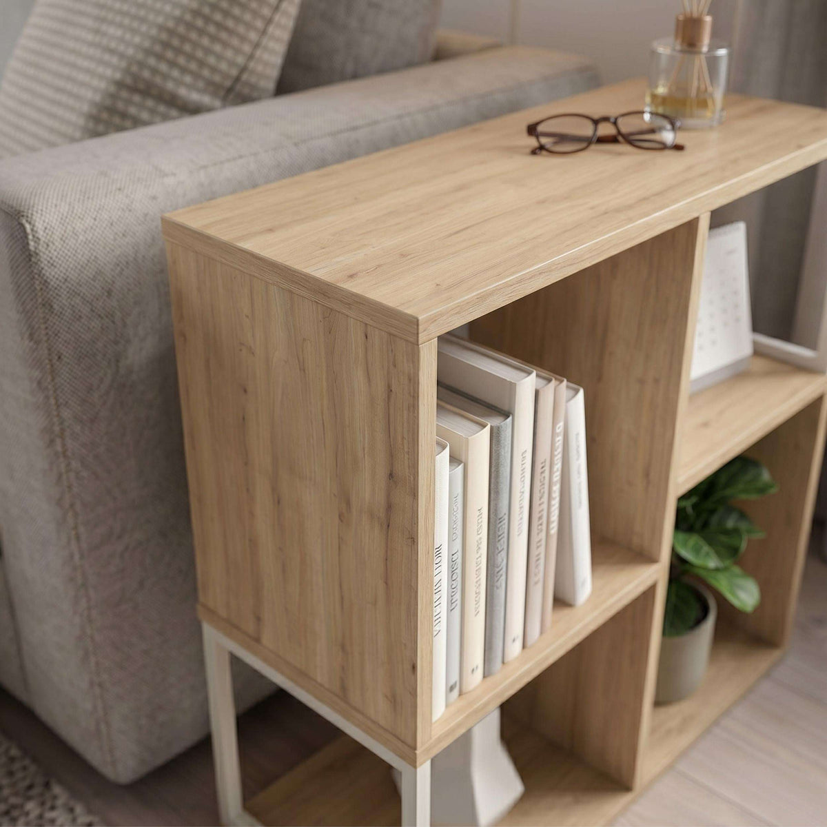 Light wood side table with open cubby shelves for books