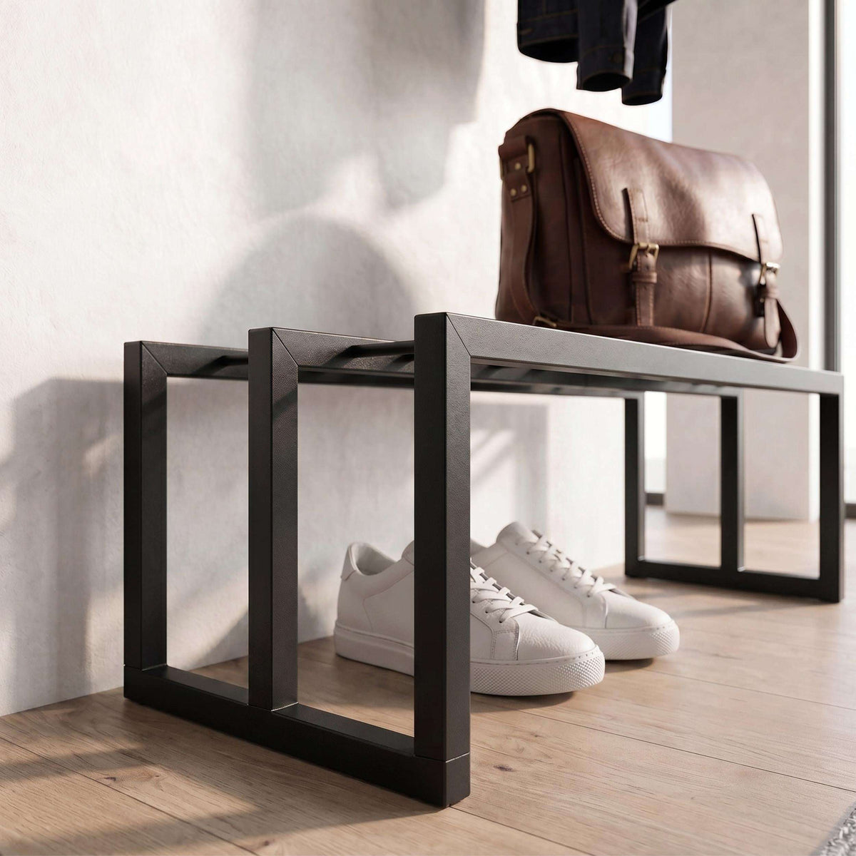 Black open shoe rack frame with brown leather bag and white sneakers