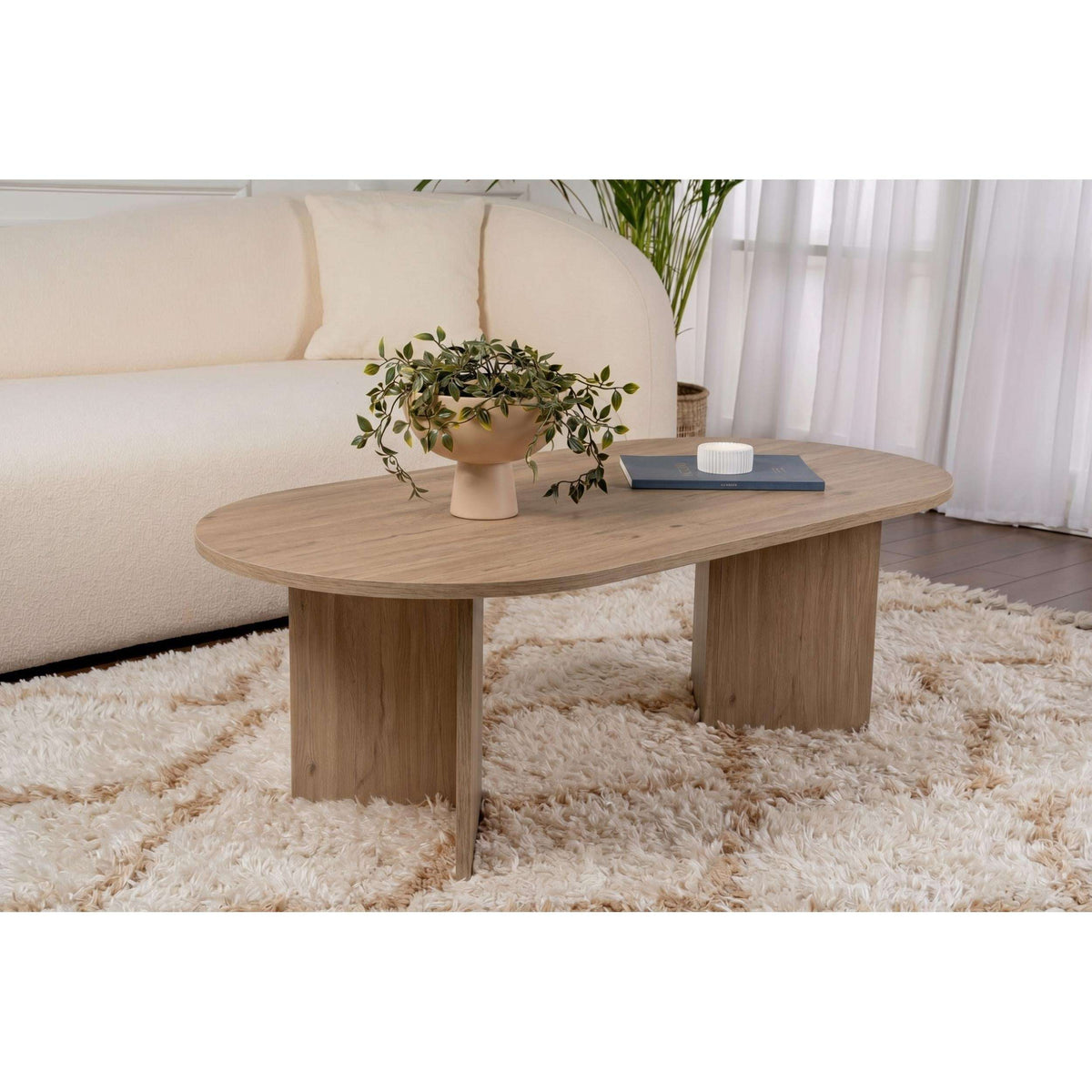 Oak oval coffee table with rounded top and sturdy tapered legs.