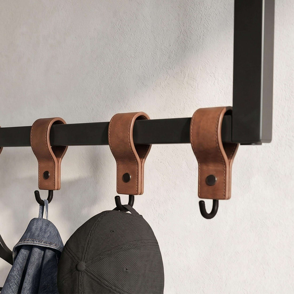 Black rail with three brown leather loops and hanging hooks