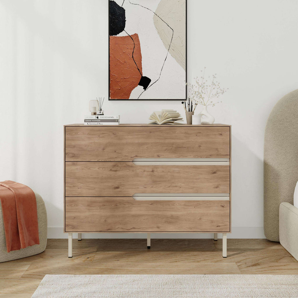Modern chest of drawers in light wood with three drawers, long handles, and thin legs