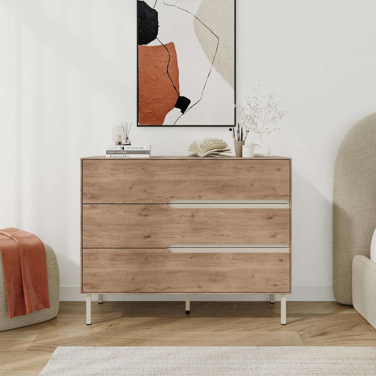Modern chest of drawers in light wood with three drawers, long handles, and thin legs