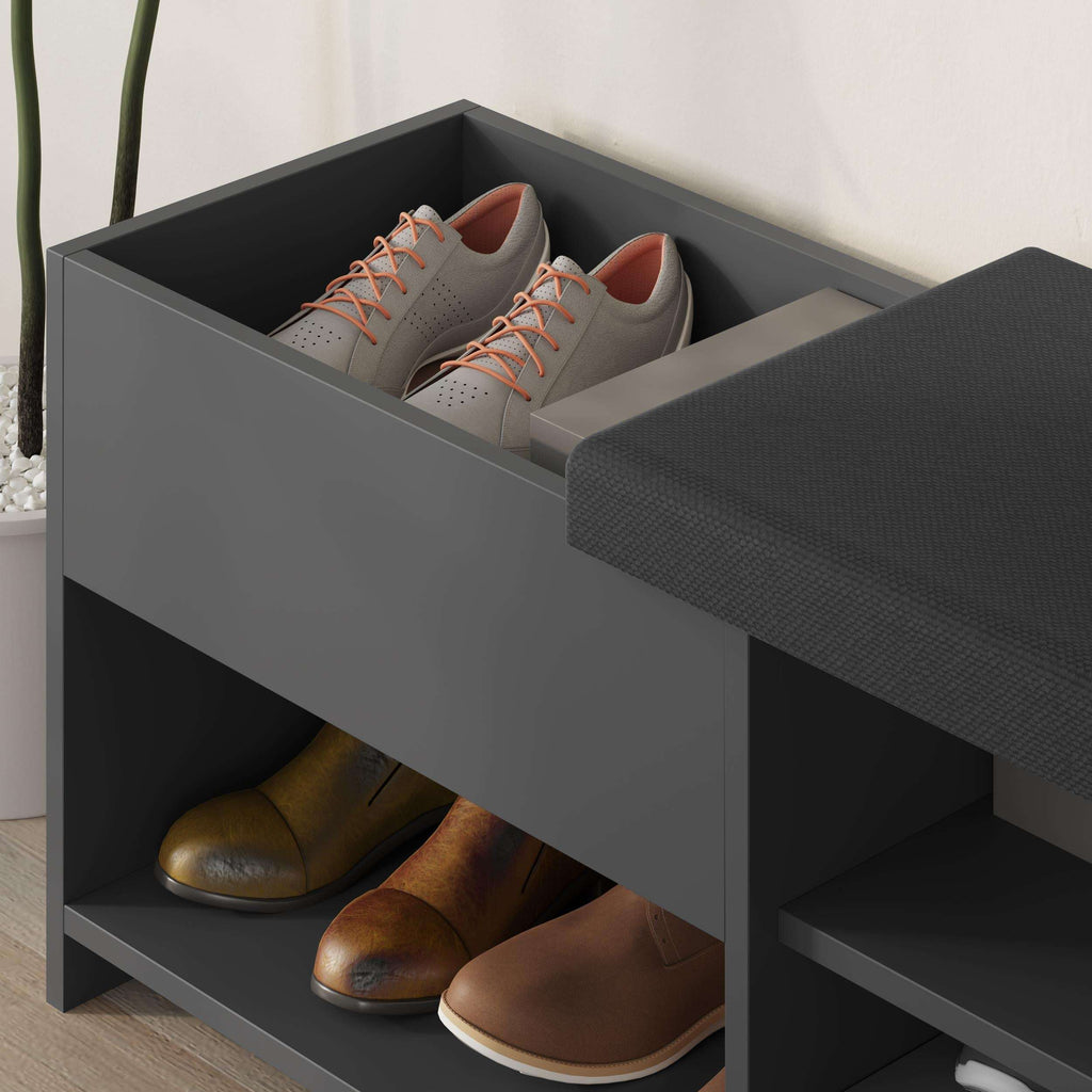 Close-up dark gray shoe bench with cushioned top and open shoe compartments.