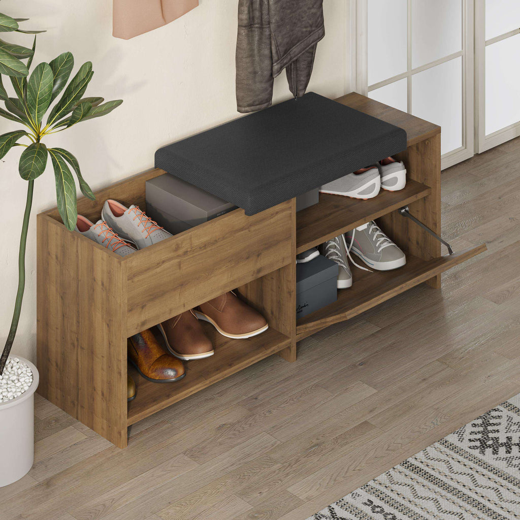 Shoe bench with dark upholstered lid and two open shoe shelves, with shoes inside.