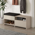 Shoe bench with hinged storage top, beige frame, black cushion, open shoe cubbies