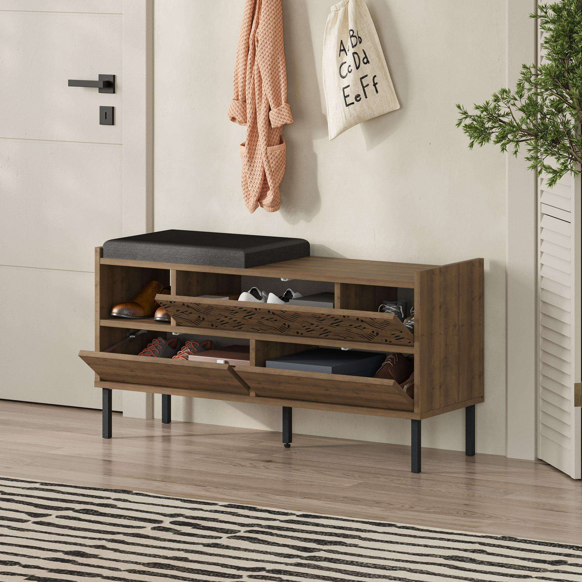 Shoe storage bench with black seat cushion, open shoe shelves, and wood doors
