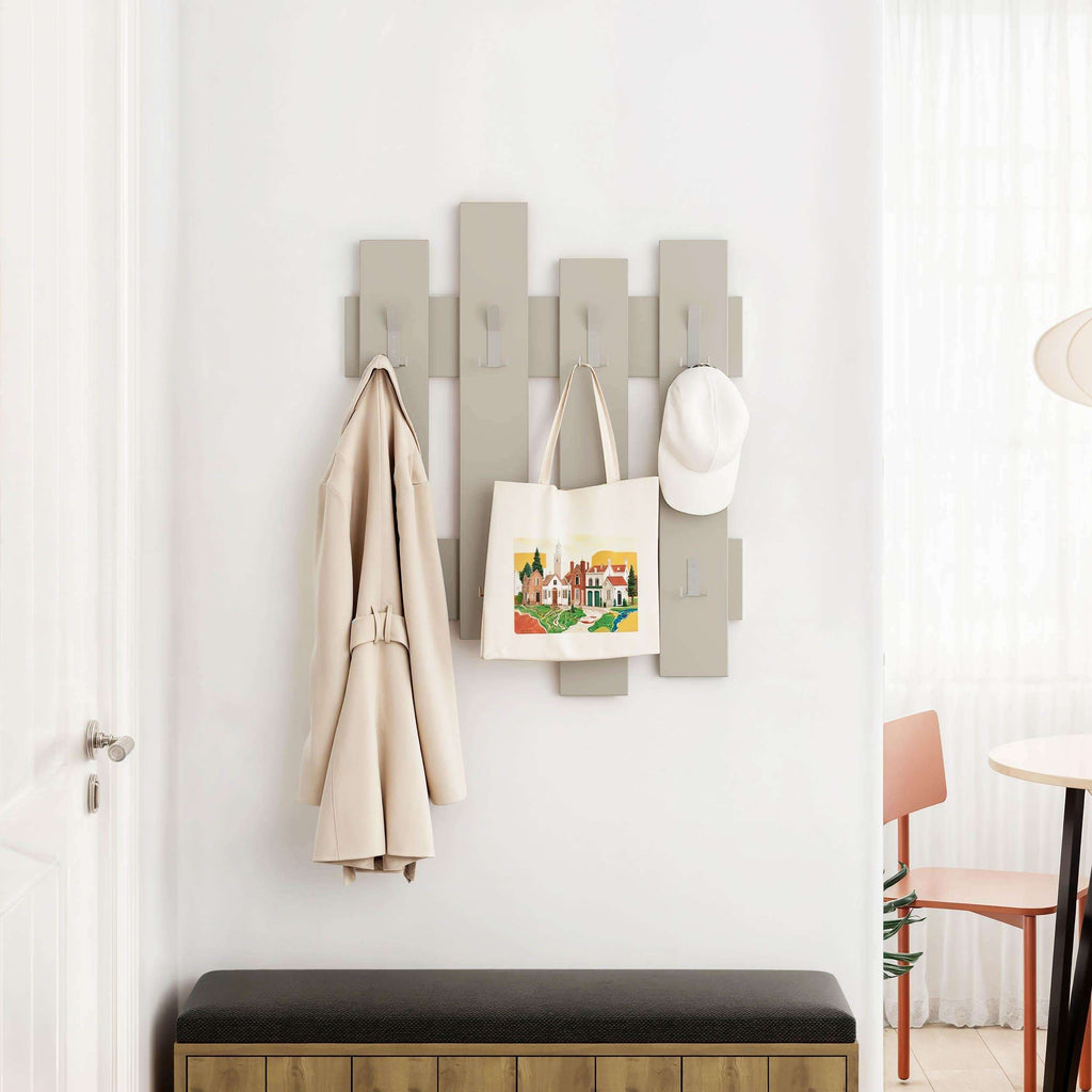 Light wood coat rack with staggered vertical panels and hooks holding coats