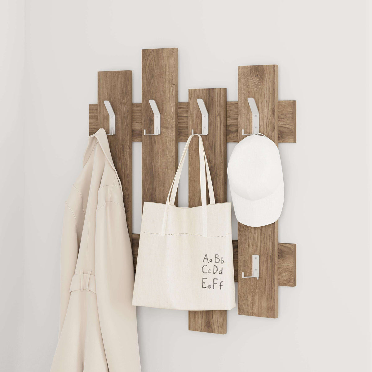 Wood wave coat rack with hanging hooks holding tote bag, cap, and coats