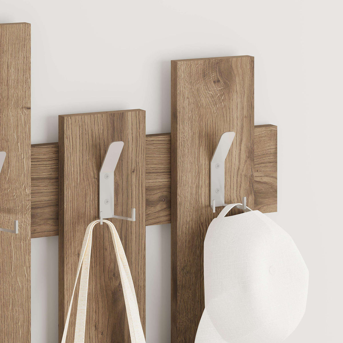 Wood wave coat rack with metal hooks holding a white bag and hat