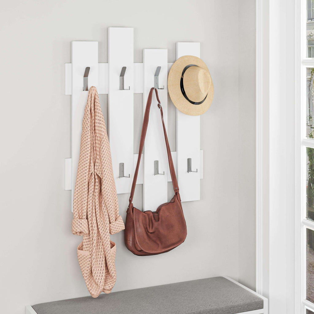 White wood coat rack with hooks holding a bag, hat, and hanging scarf
