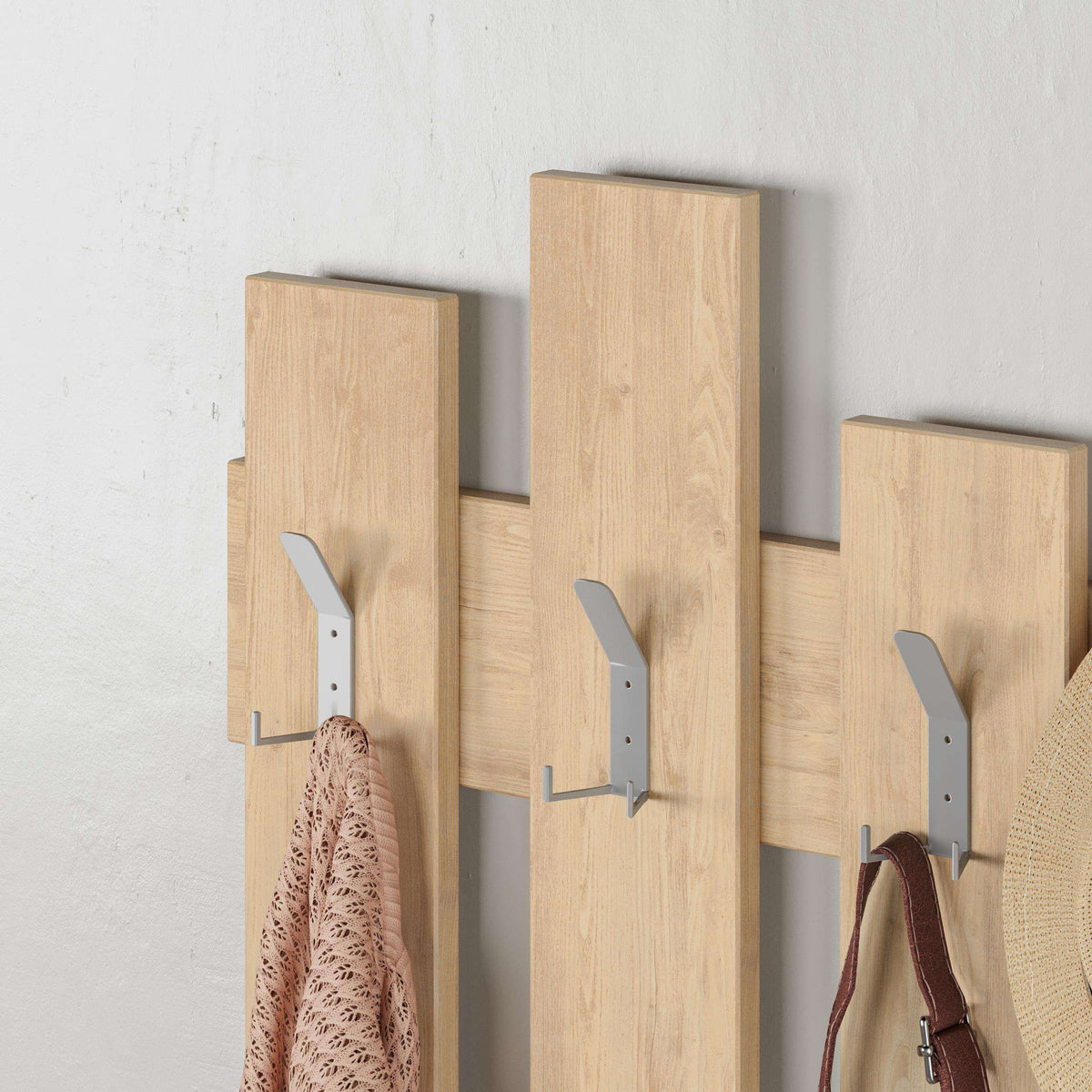 Oak coat rack with mounted hooks, holding a coat and bag on the wall