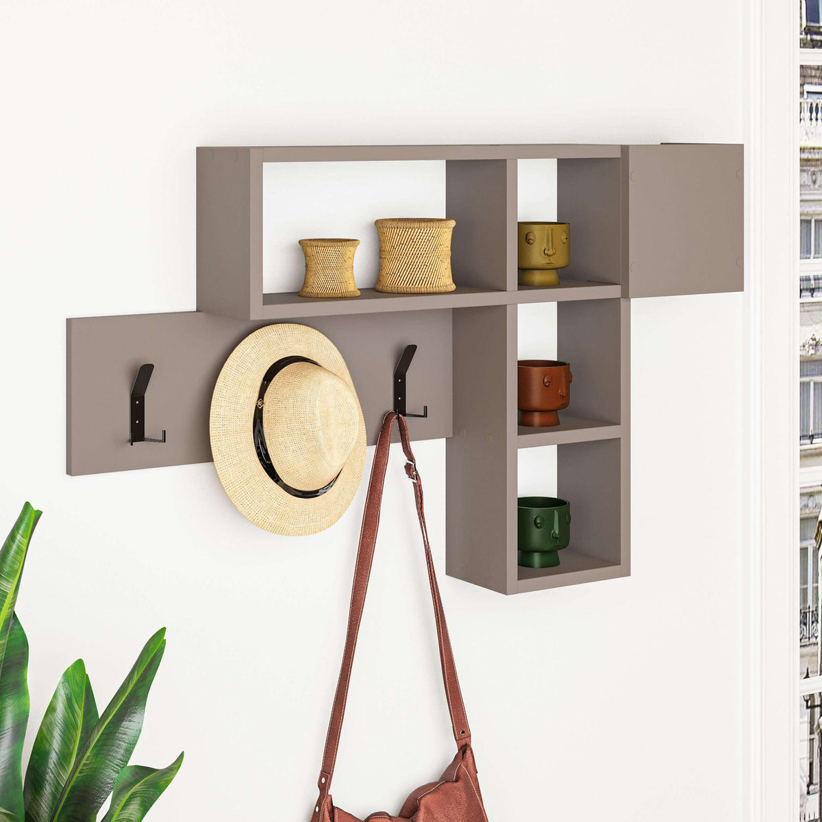 Wall-mounted game hanger with dark shelves, open cubbies, and three black coat hooks; hat and bag.