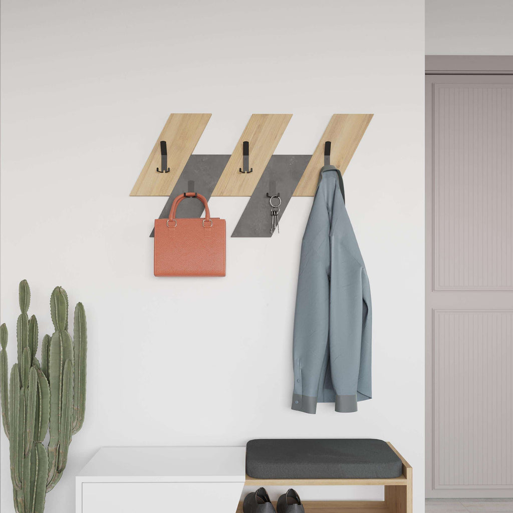 Wall-mounted coat hanger with light oak slats and black hooks holding coats and keys