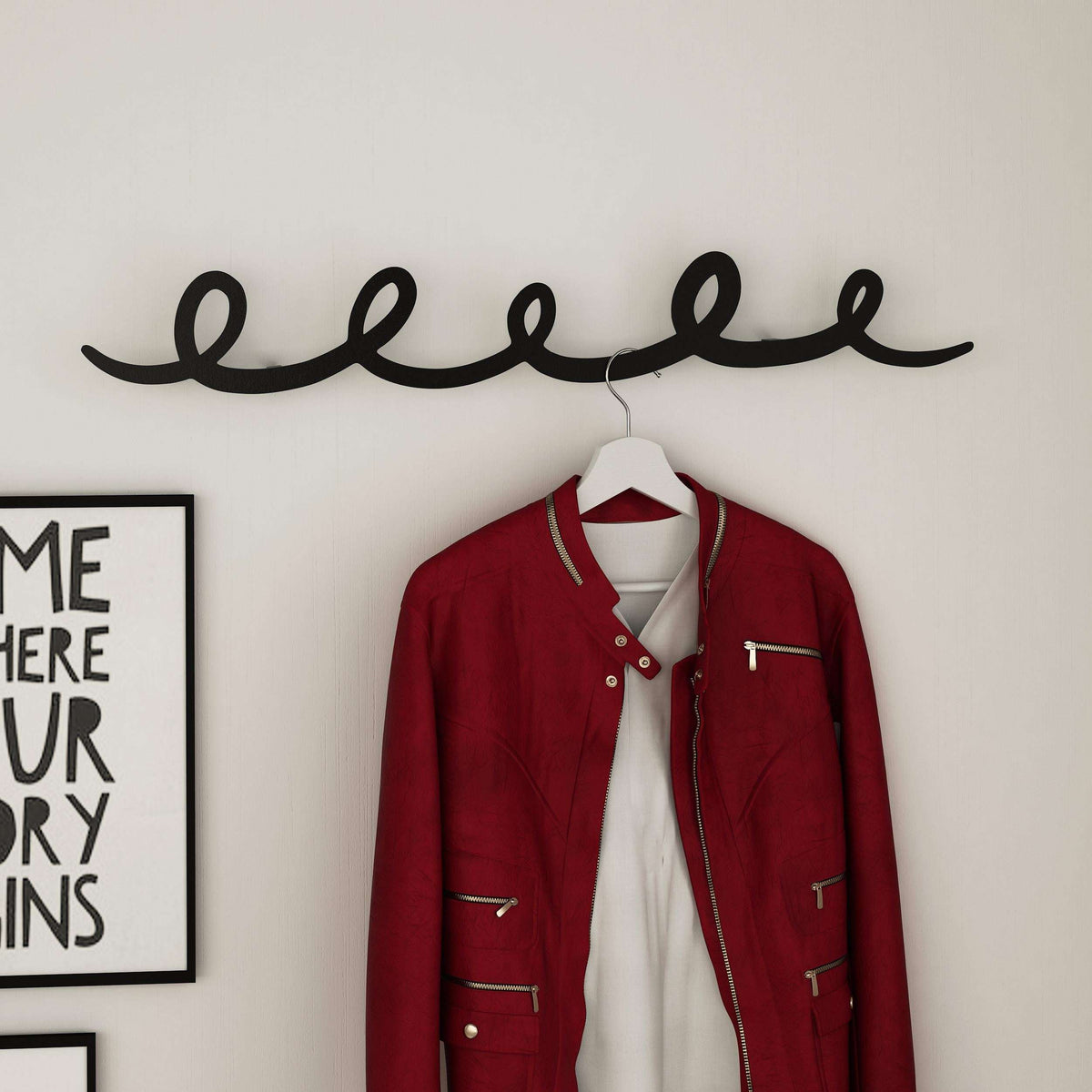 Metal script hanger with curved hook, supporting a red jacket