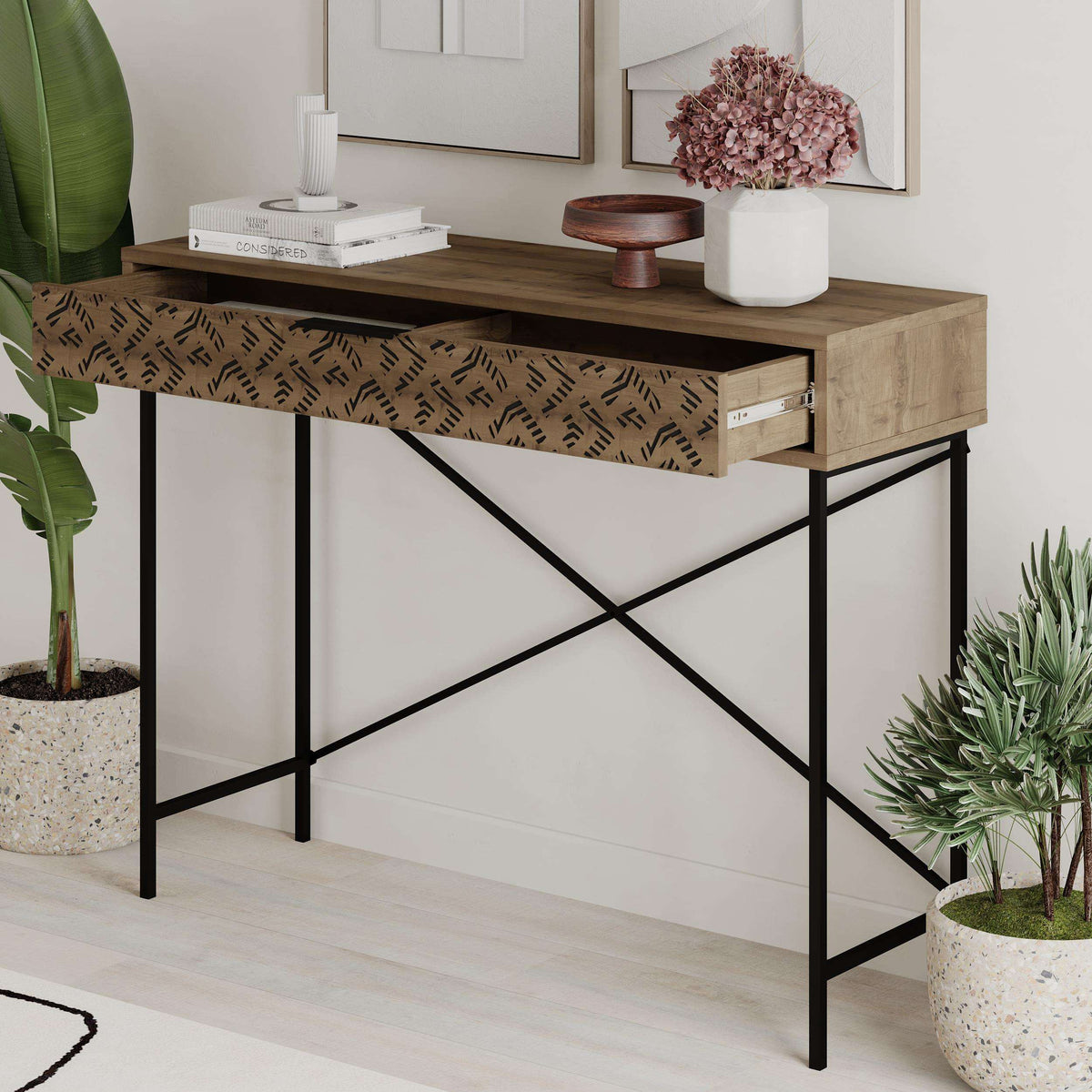 Console display unit with patterned drawer front, open shelf, and black metal X-frame legs