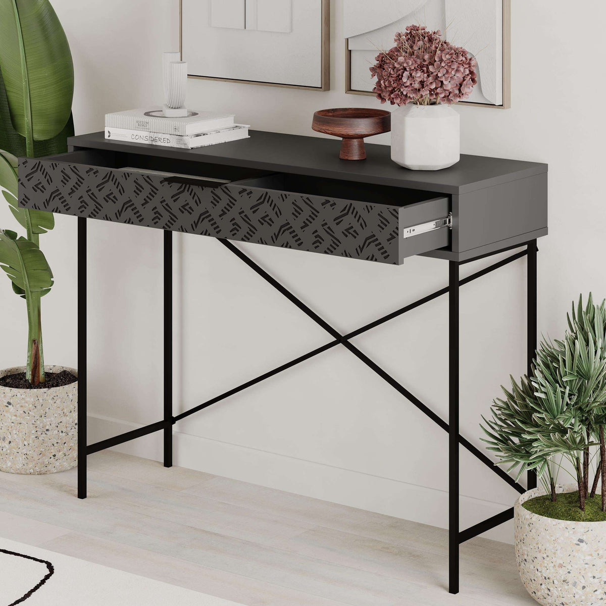 Console display unit with drawer, dark top and patterned front, black metal cross legs