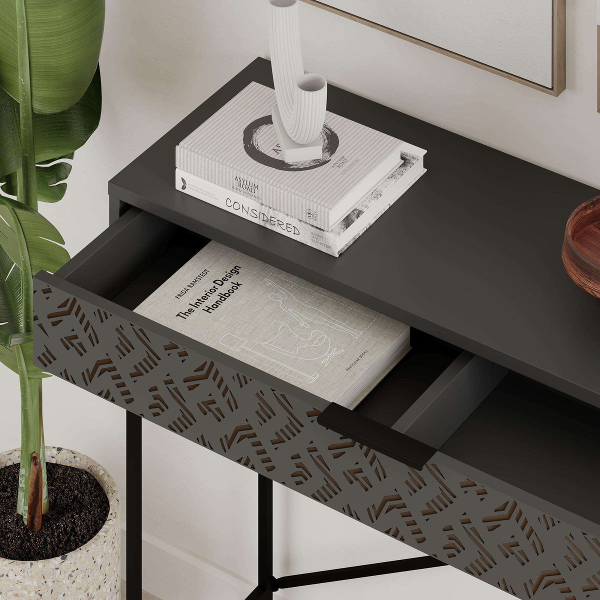 Console display unit with open lower shelf, patterned panel, black metal X brace