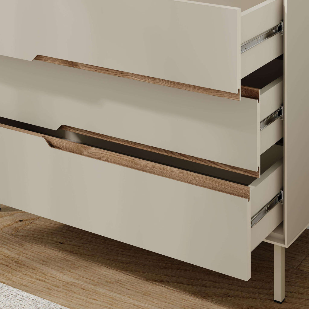 Close-up of modern chest of drawers: open drawers, wood bar handles, metal drawer tracks