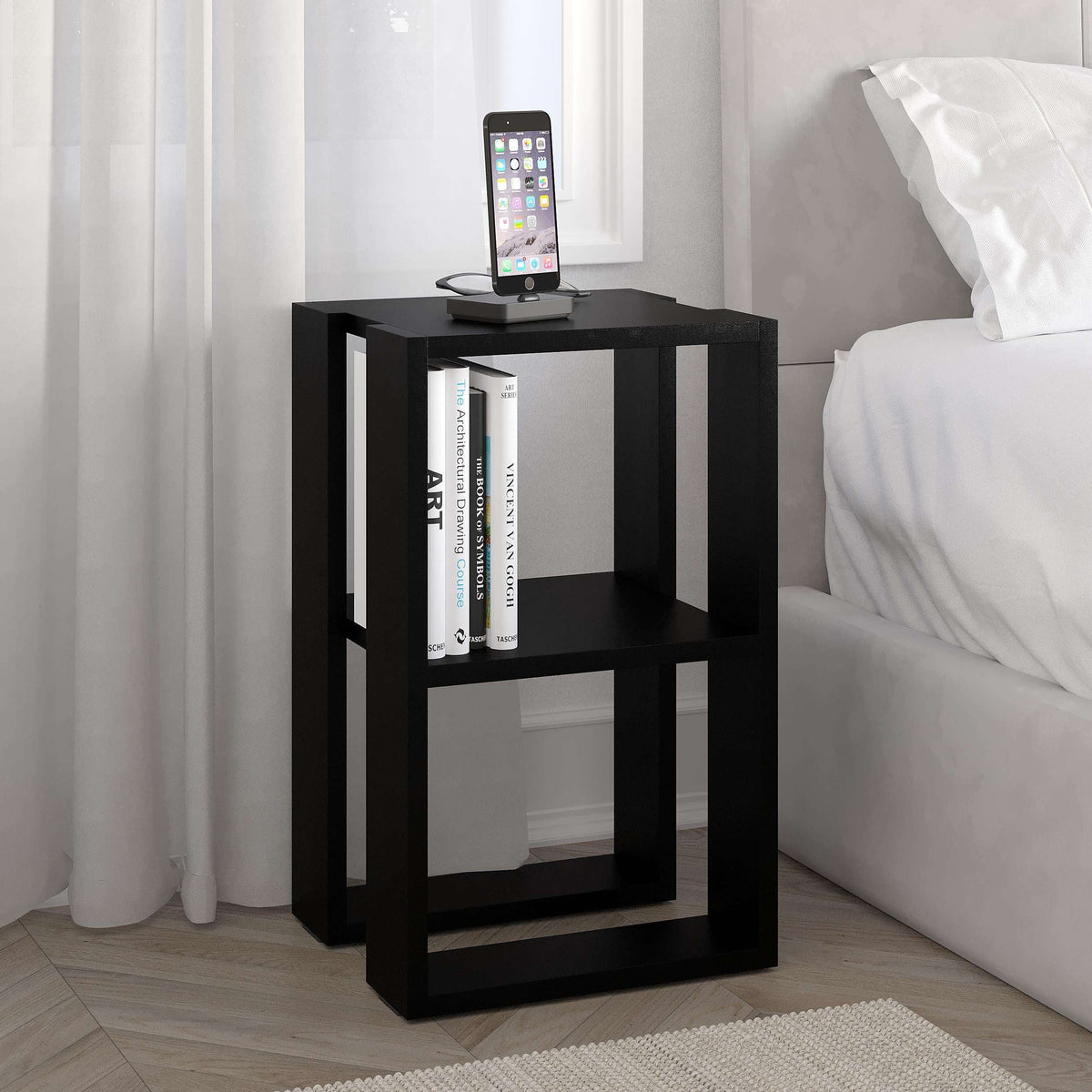 Black bedside table with smartphone on top and two open shelves