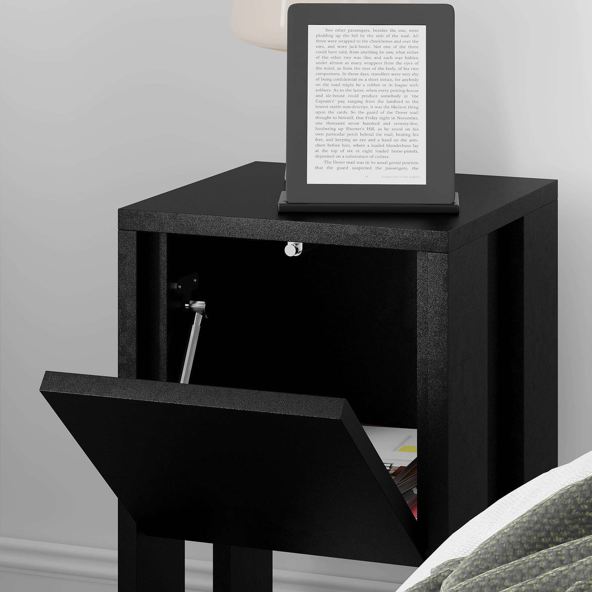 Black bedside table with open cabinet door and open lower shelf, tablet on top.