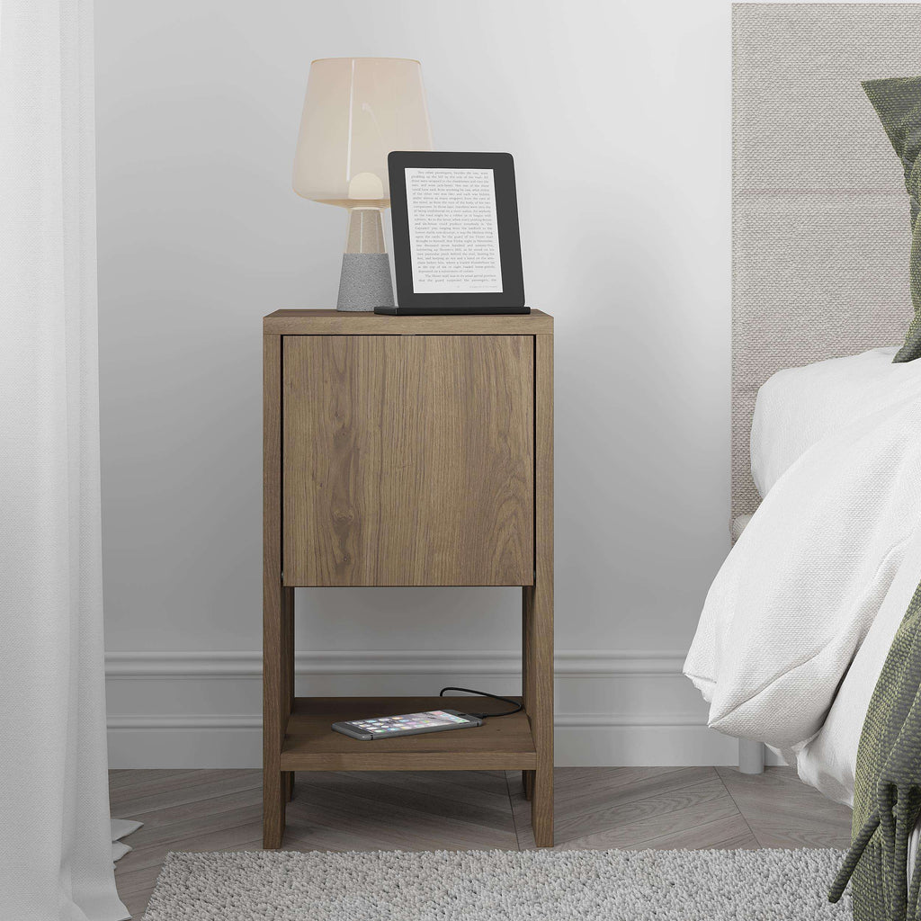 Woodgrain bedside table with open lower shelf and front door panel, in bedroom setting.