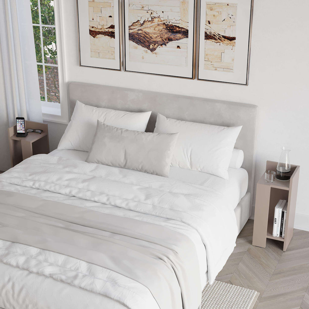 Narrow light gray bedside table with open shelf beside bed, book and phone
